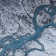 Aerial image of Greenland, showing rivers of meltwater and patches of dark ice, via Marco Tedesco/Lamont-Doherty Earth Observatory